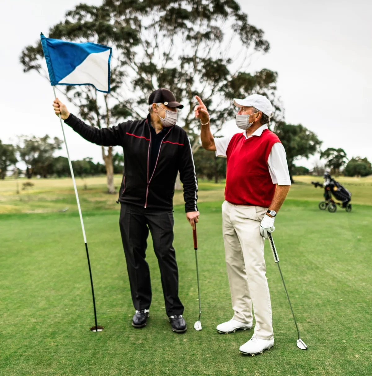 Masked golfers chat on the green