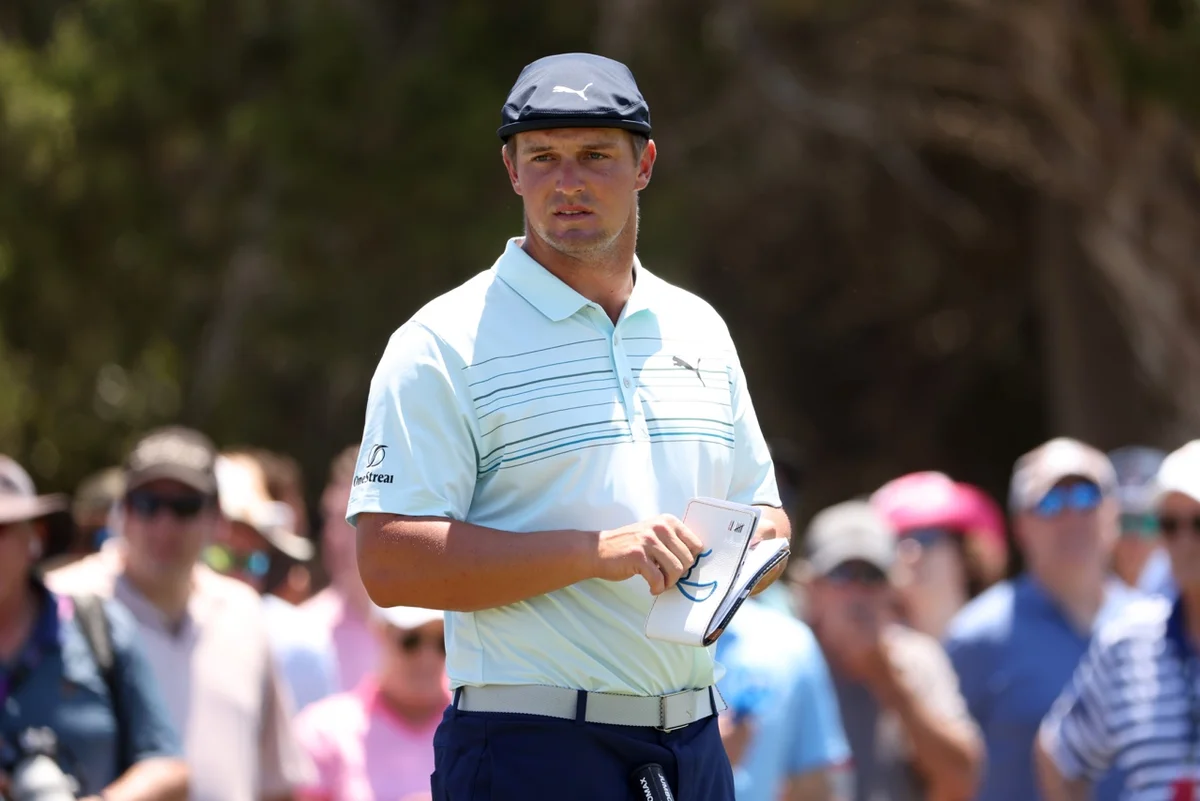 Bryson DeChambeau studies a yardage book