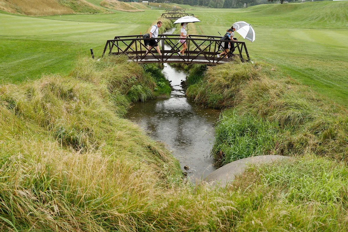 Players cross Inverness' 6th hole bridge