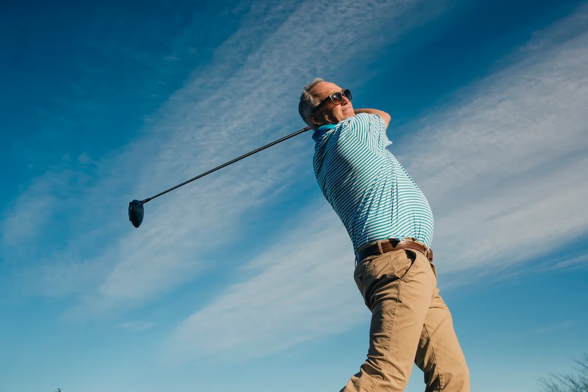 Man holding golf swing follow through