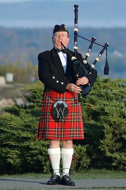 Scottish man in kilt playing bagpipes
