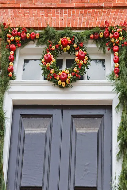 Doorway with Christmas wreath of apples and pine boughs