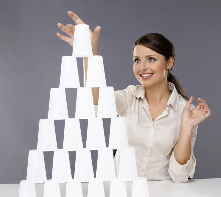 Girl building pyramid of cups
