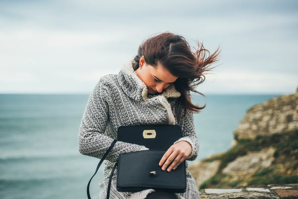 Young woman searching in her purse