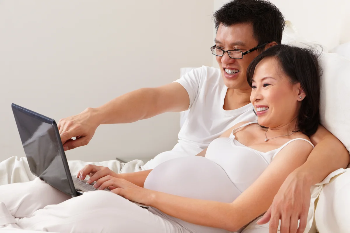 pregnant couple with laptop