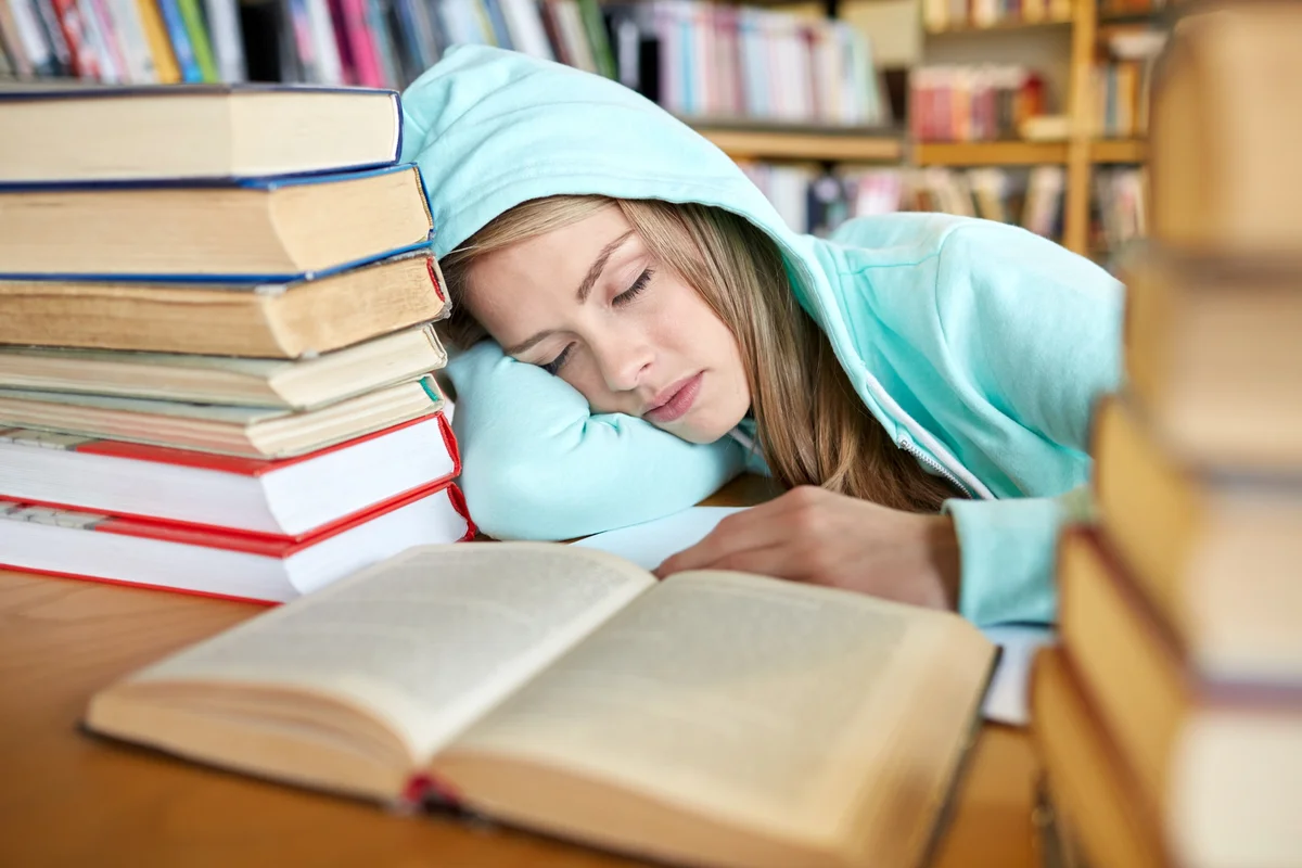 Student with books sleeping