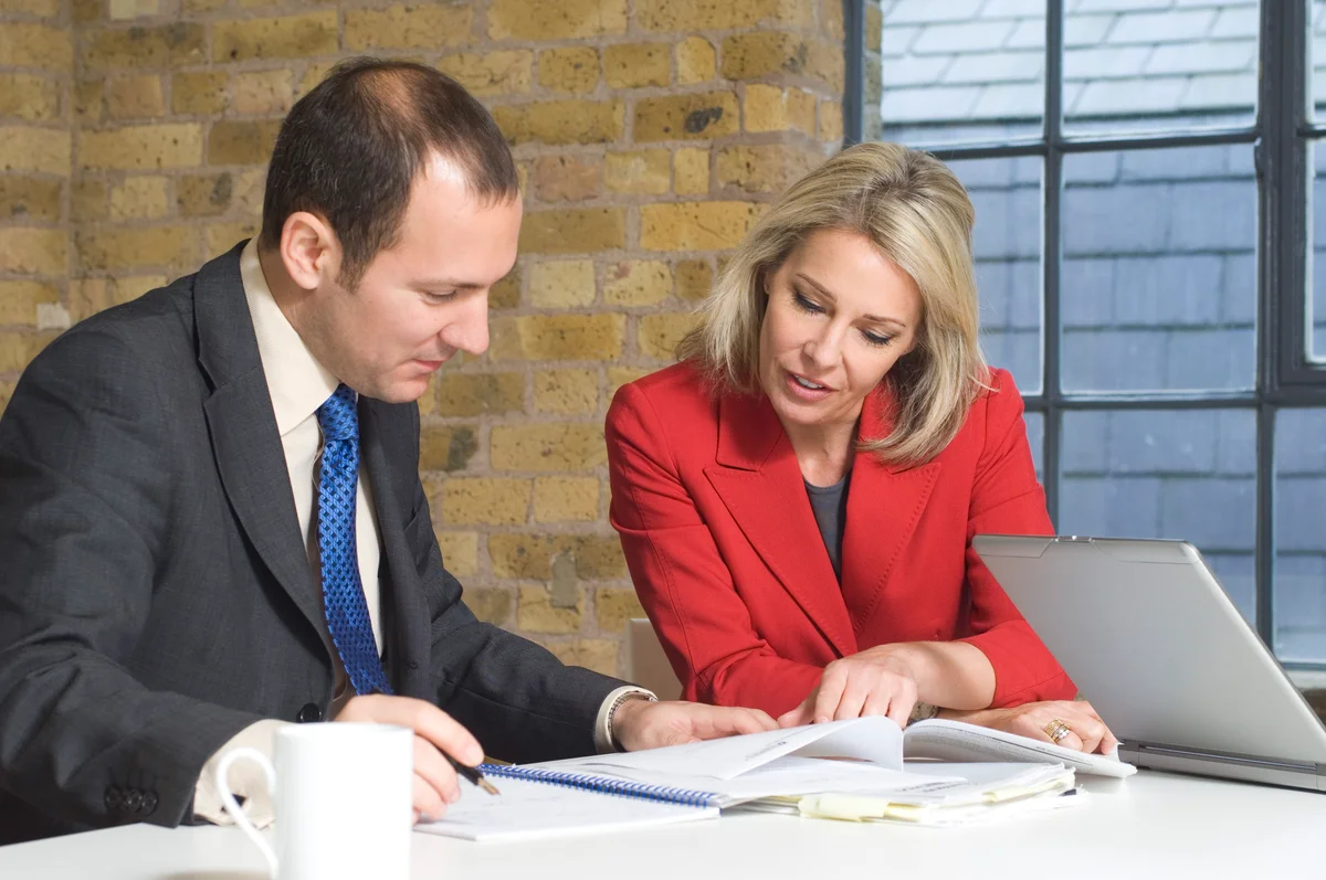 Businessman and businesswoman looking at documents
