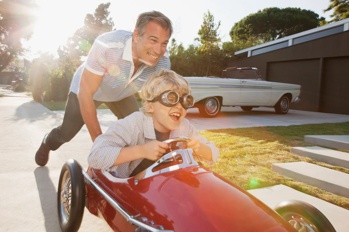 Father pushing son in go cart