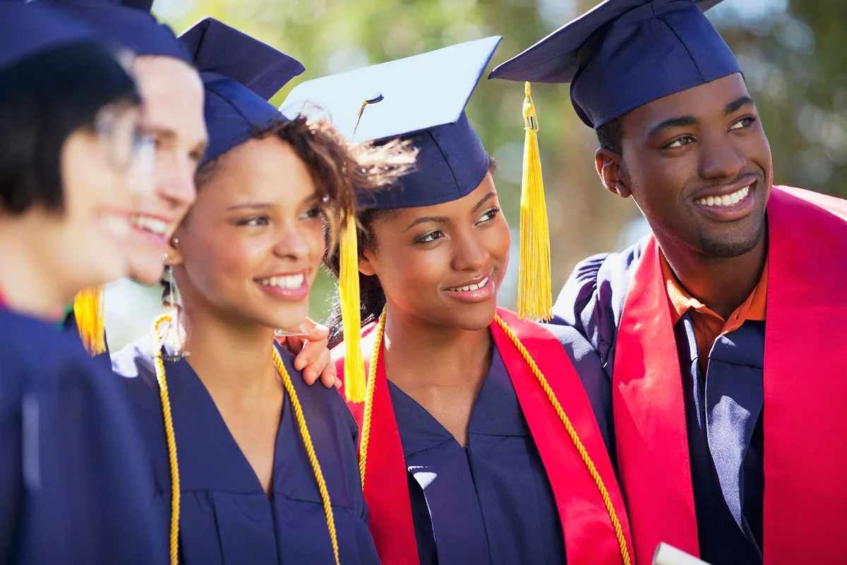 Graduates smiling together in cap and gown