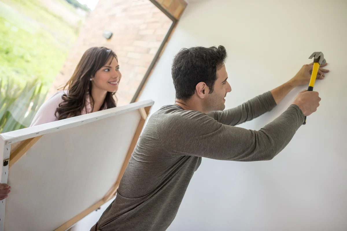 Couple hanging a painting