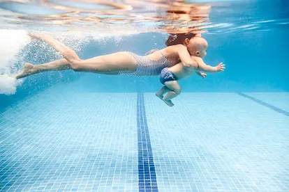 Mother swimming with baby boy