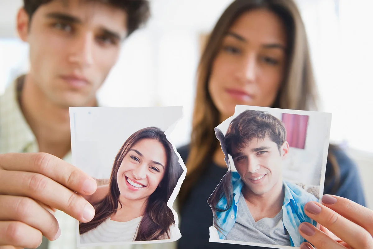 Couple holding torn photograph