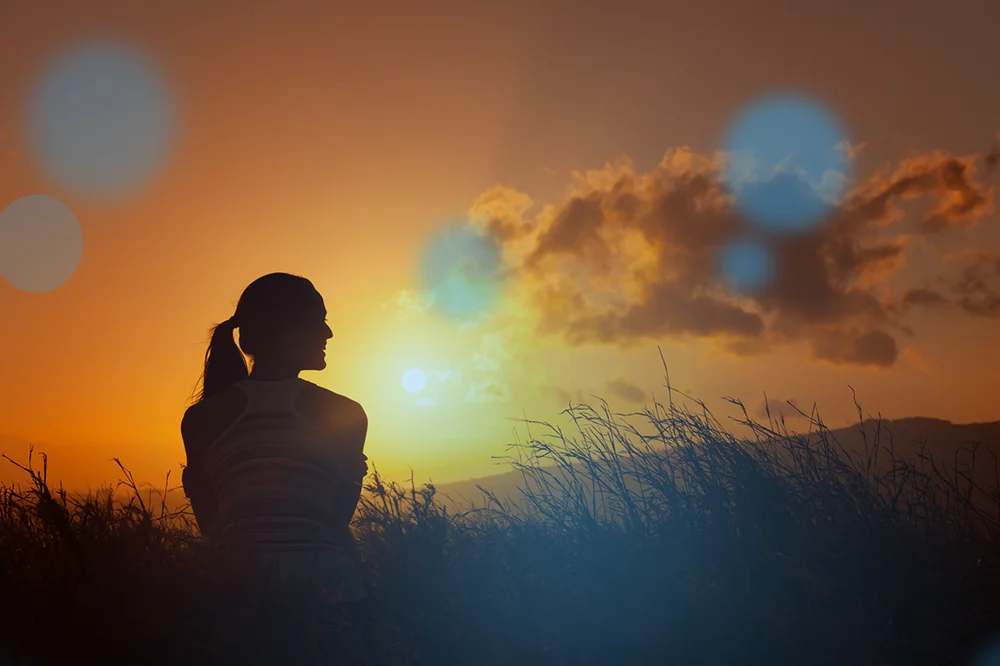 woman watching sunset with blue orbs