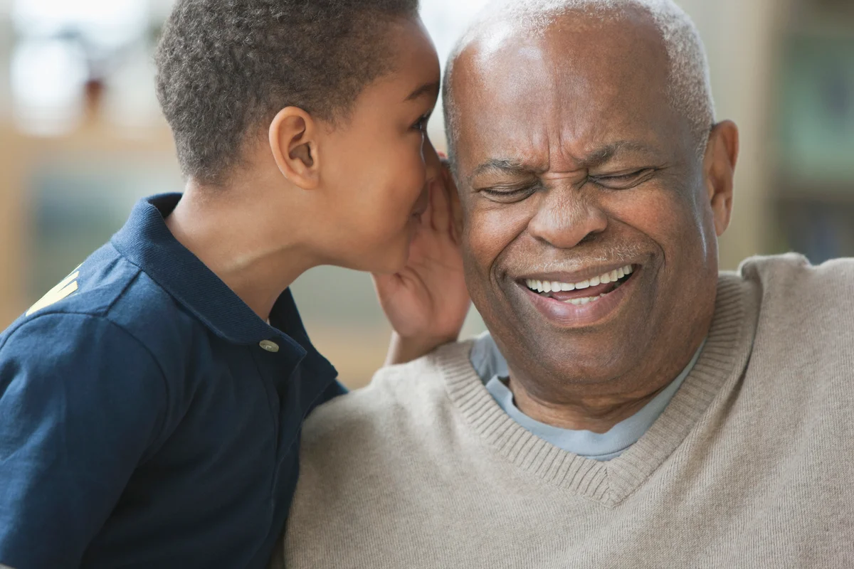 Boy telling grandfather a secret