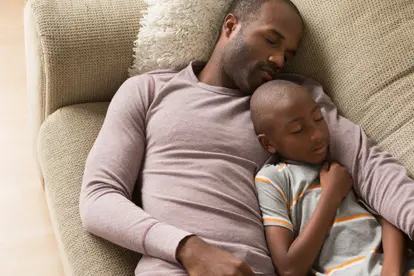 Father and son sleeping on sofa