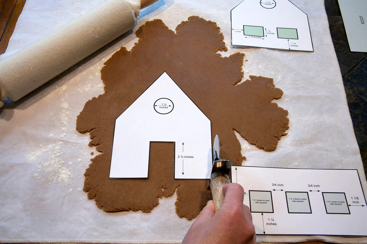 Cutting out gingerbread house from dough