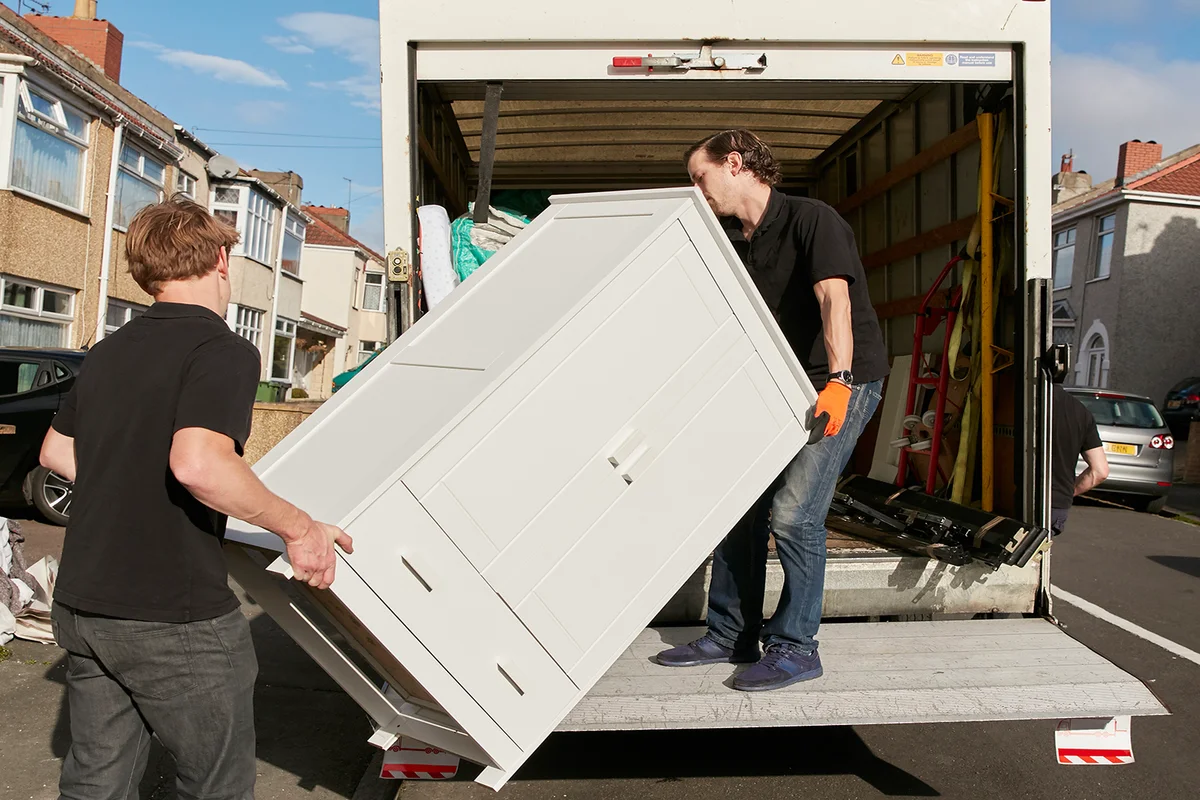 men lifting dresser onto van