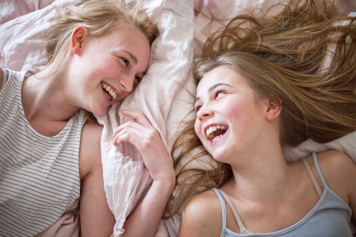 Laughing girls on bed