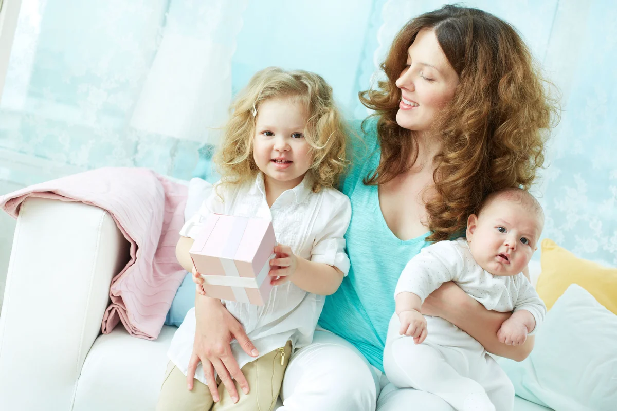 Mother with toddler, gift and baby