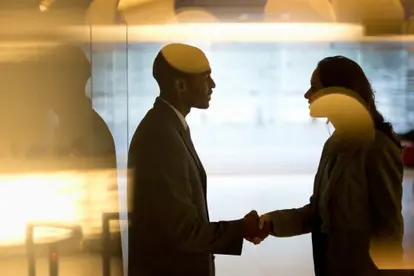 Businessman and businesswoman handshaking in lobby