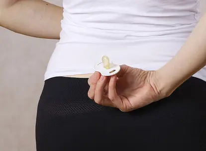 Holding pacifier behind back