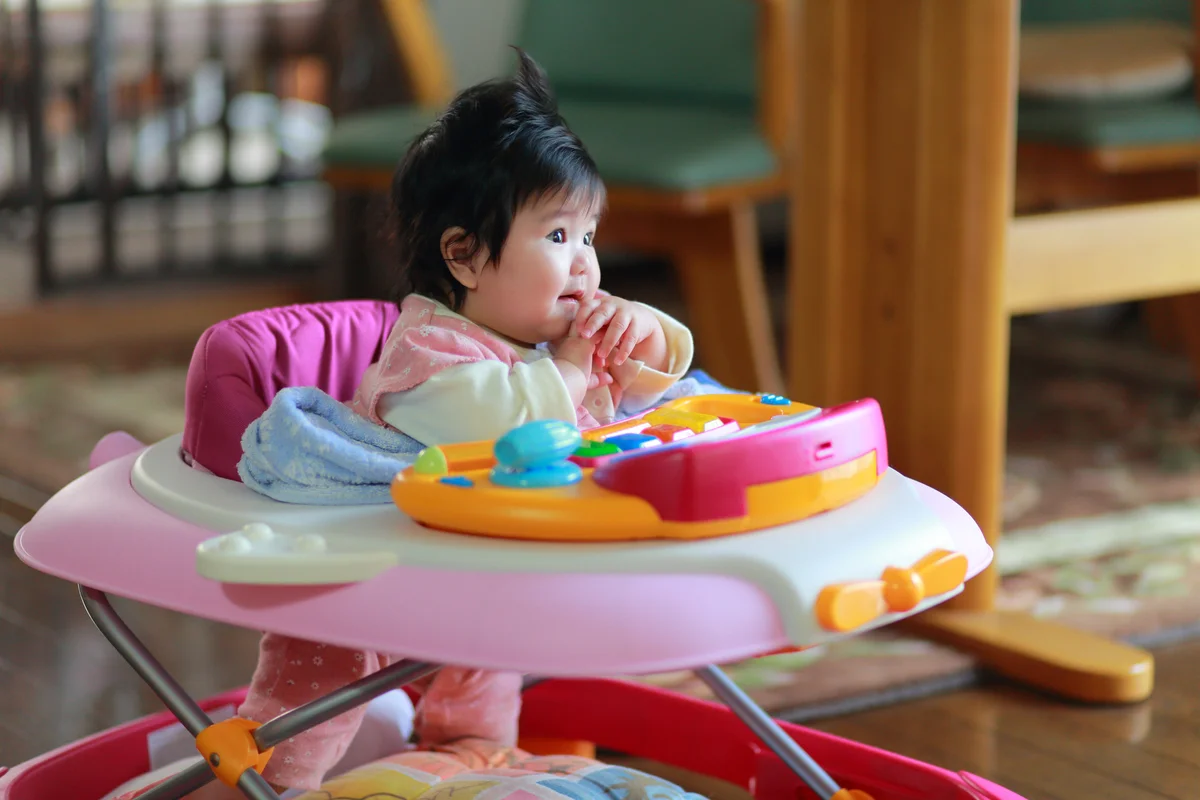 baby sitting on a walker
