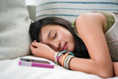 Teenage girl asleep on sofa