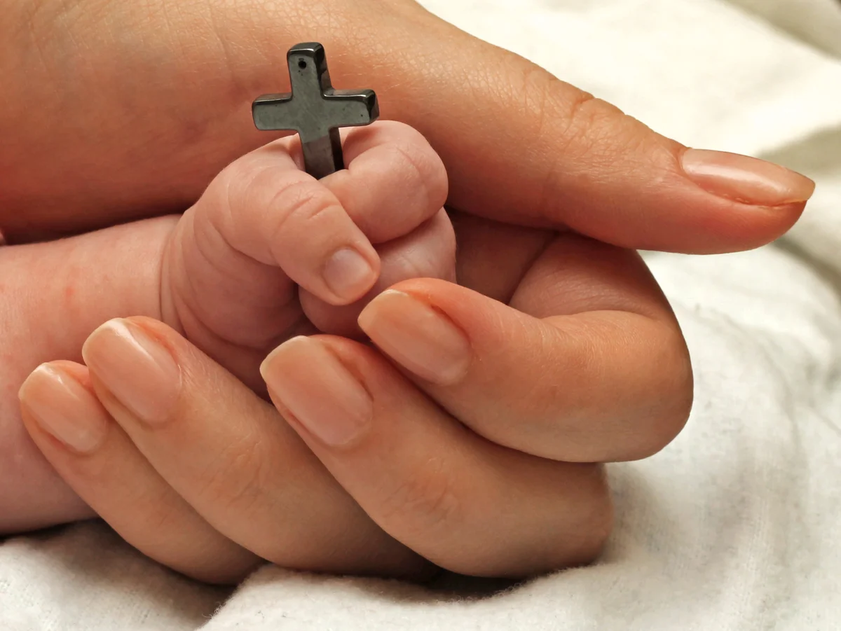 Christian baby holding a cross