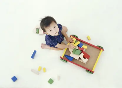 boy putting blocks in wagon
