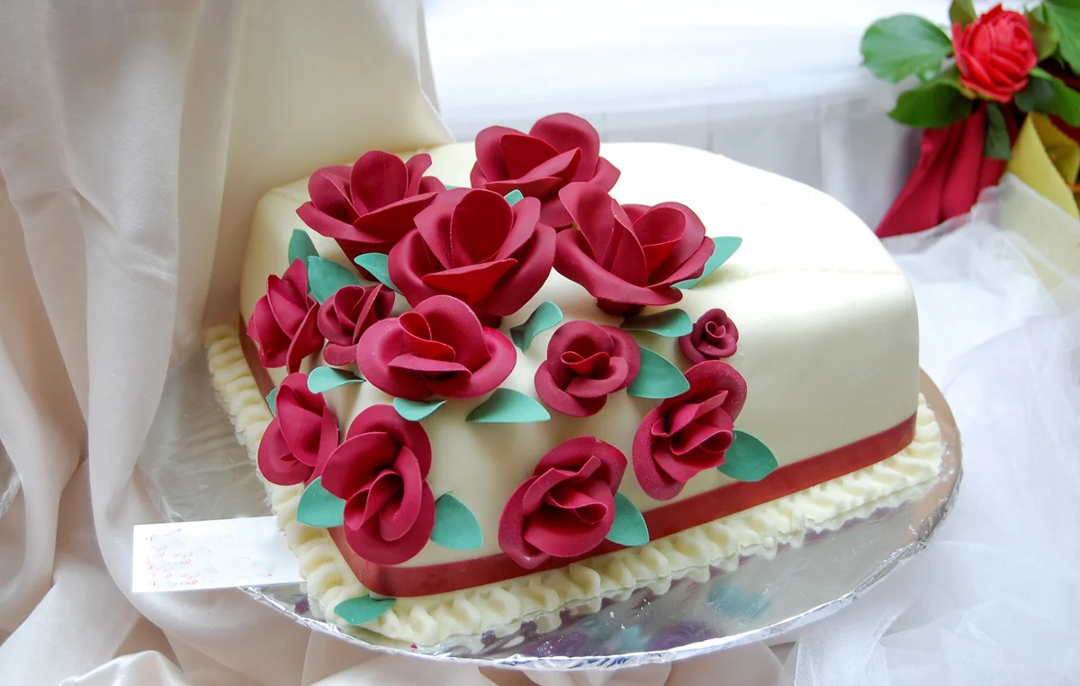 White wedding cake with red roses