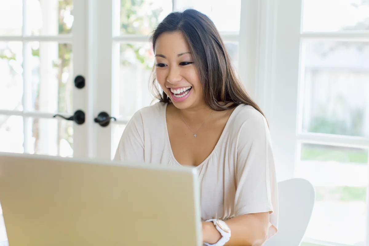 Laughing woman using laptop