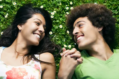 Teenage couple laying in grass