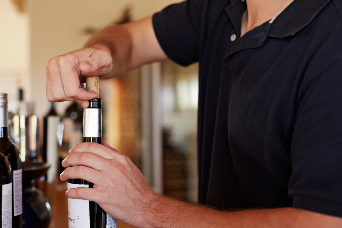 pushing cork into wine bottle
