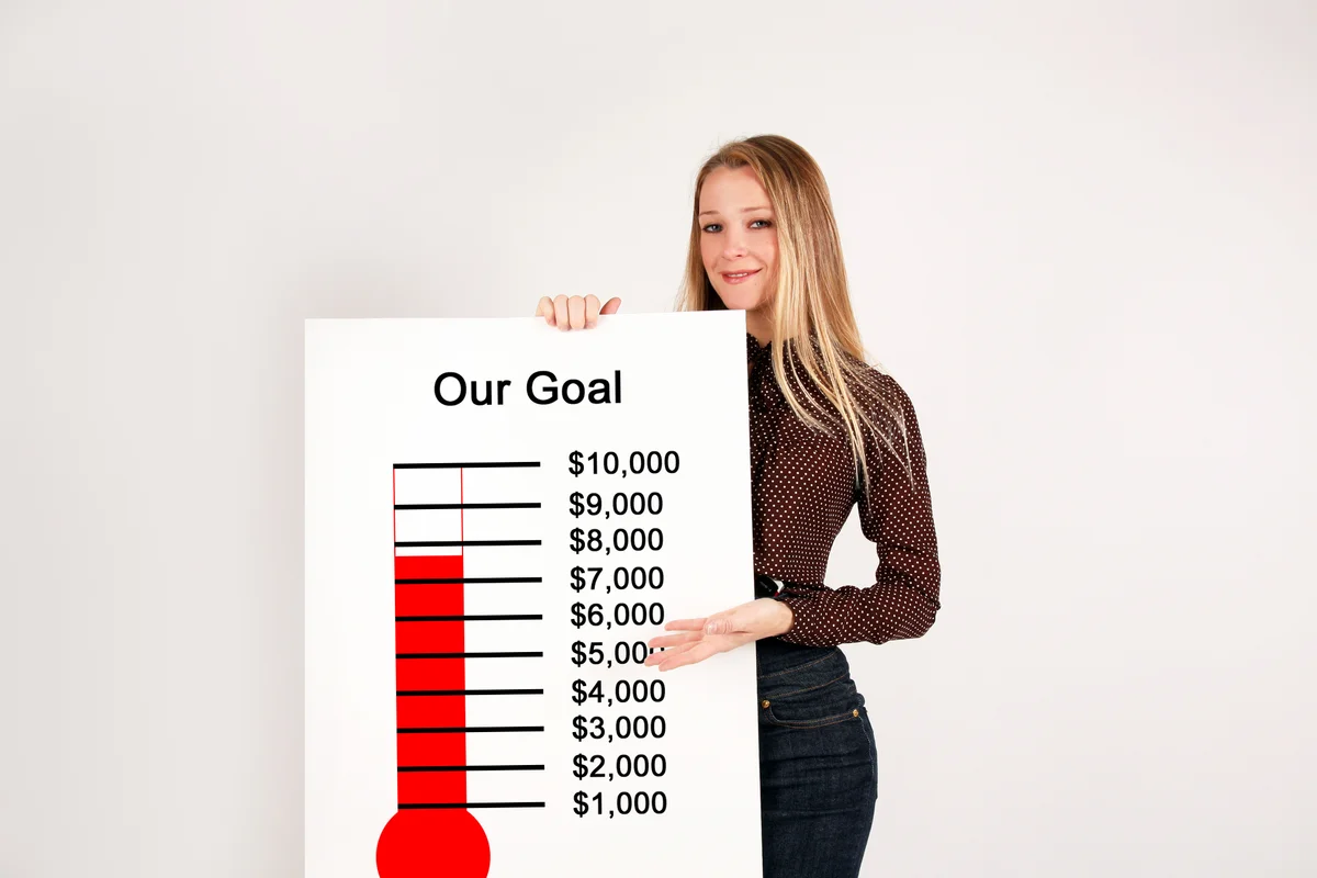 Girl holding fundraising thermometer