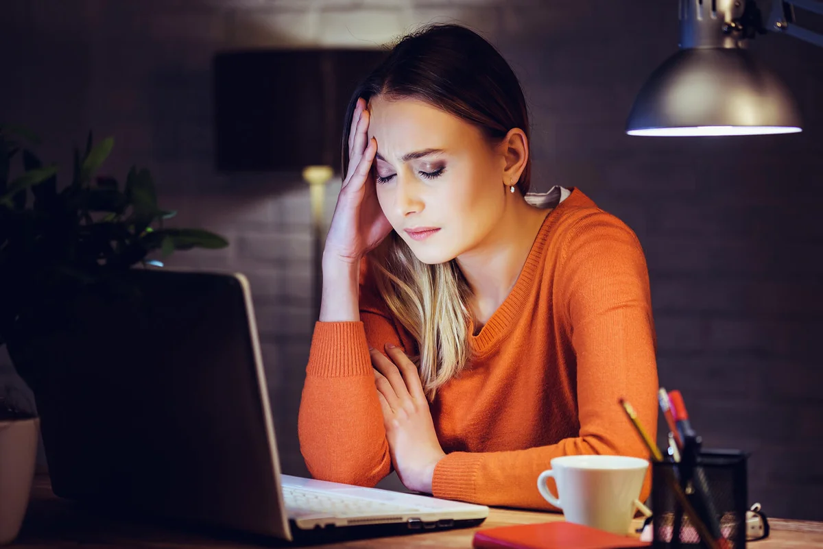 Sad woman writing on laptop