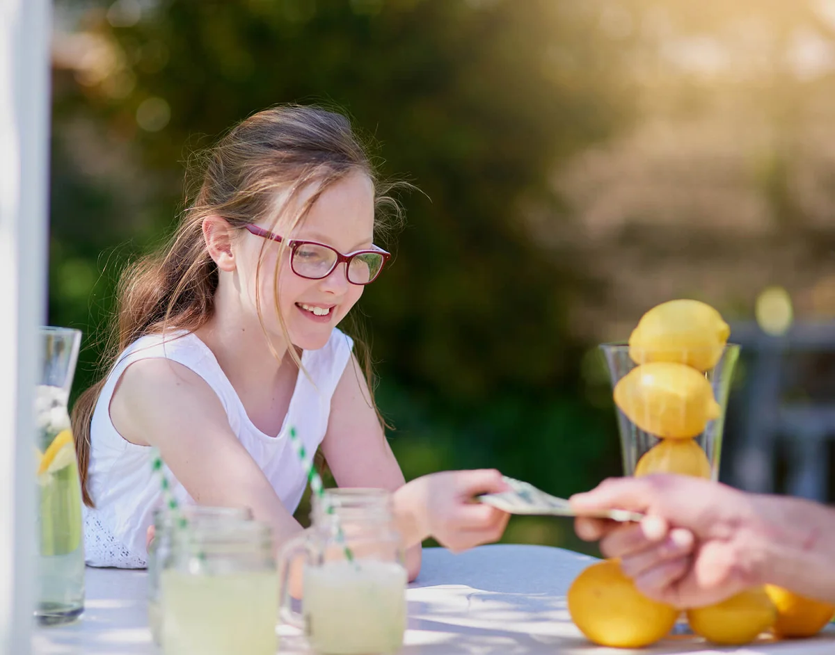 Girl selling lemonade from her stand