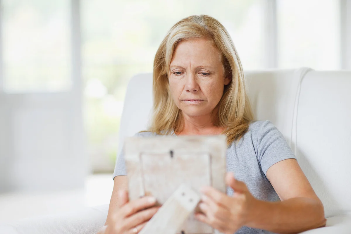 Woman crying holding a picture of her husband