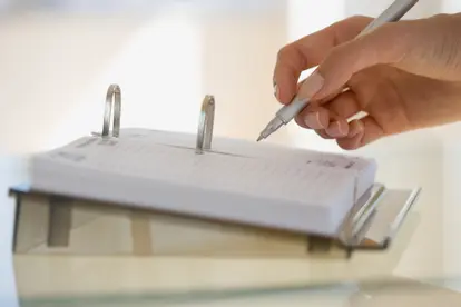 Woman writing on desk calendar