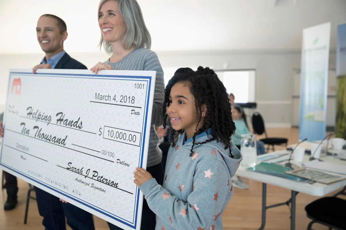 holding large donation check
