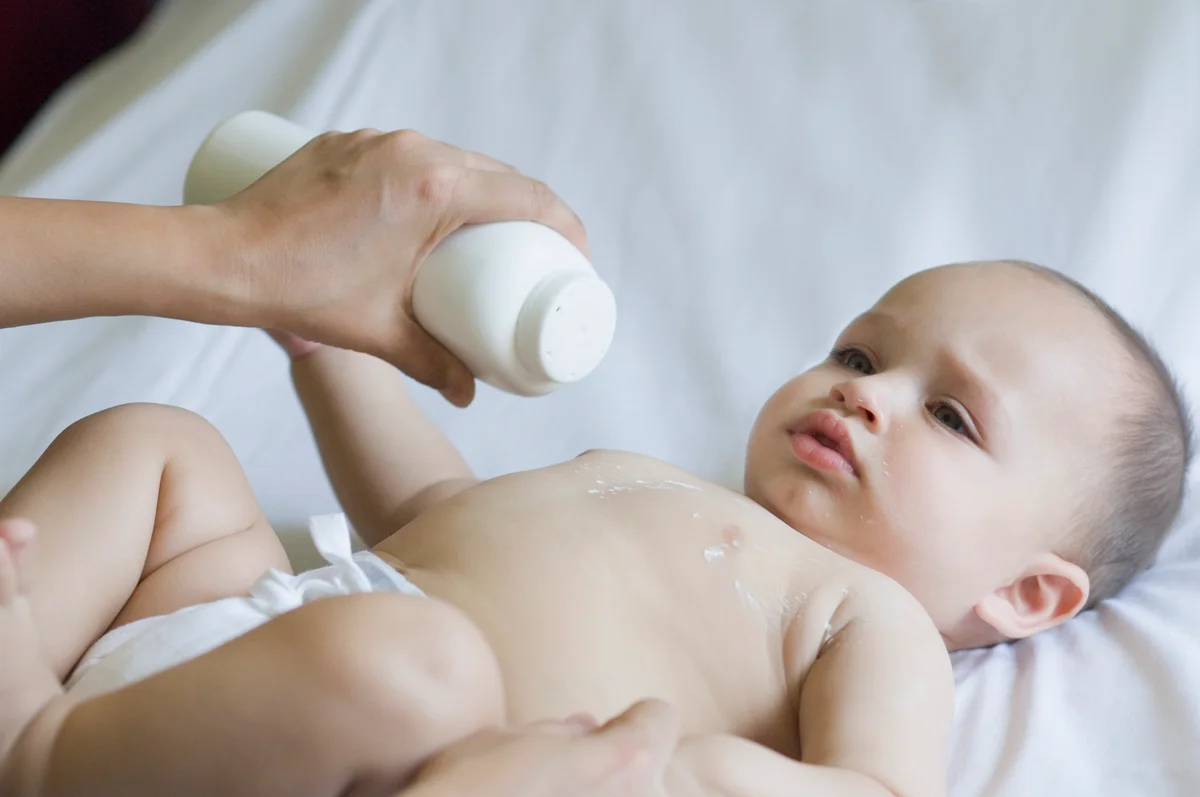 putting talcum powder on baby