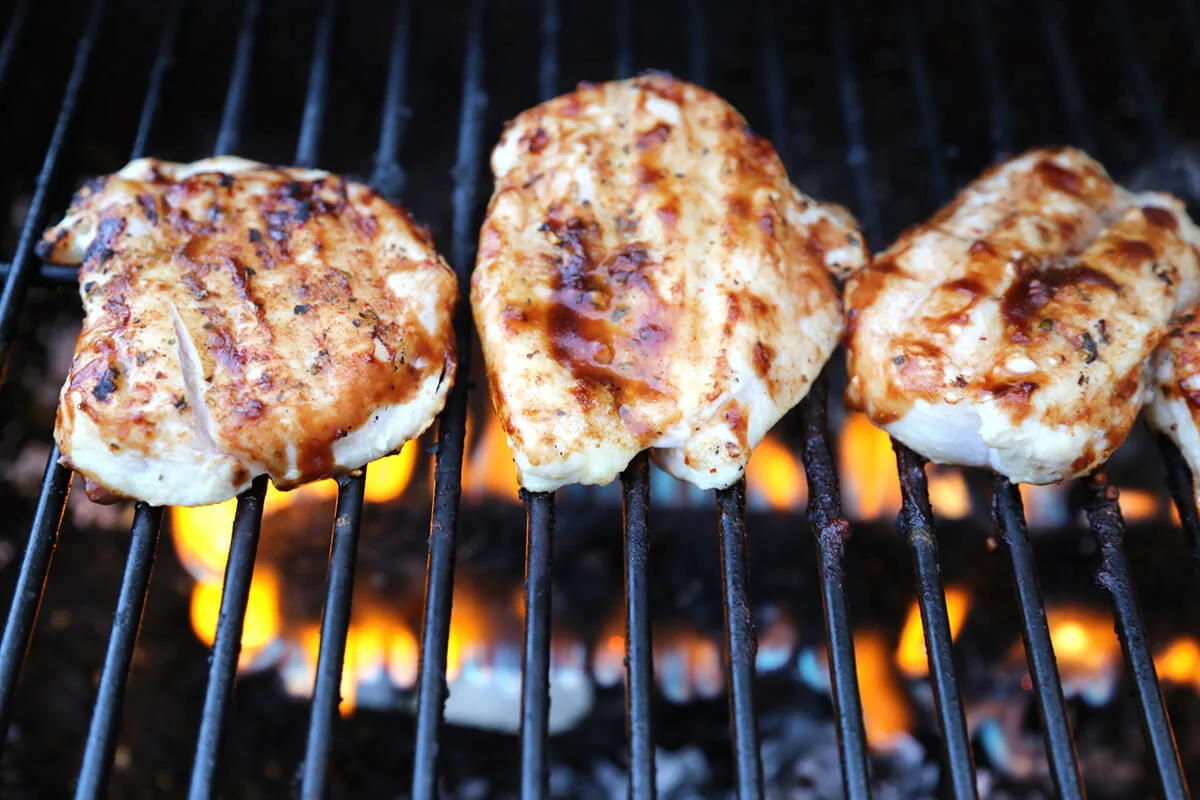 Chicken meat with barbecue sauce cooking on the grill