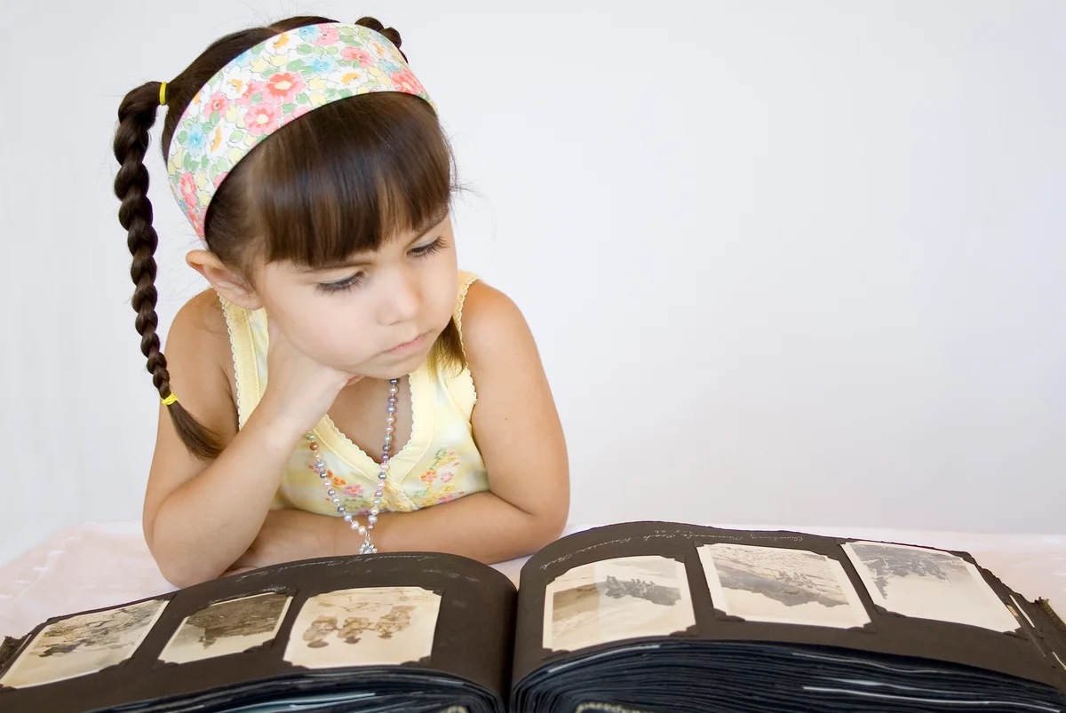 Child looking intently at old photos