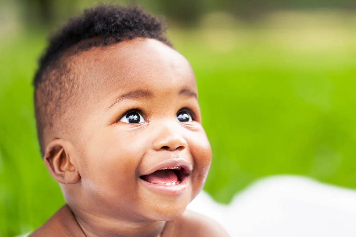 Smiling little baby with a side-shave haircut