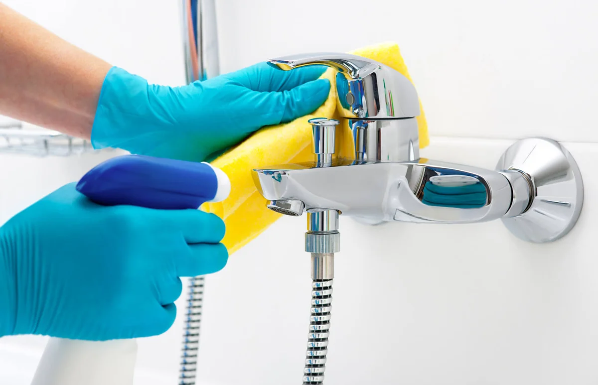 Person cleaning bathroom mold with bleach