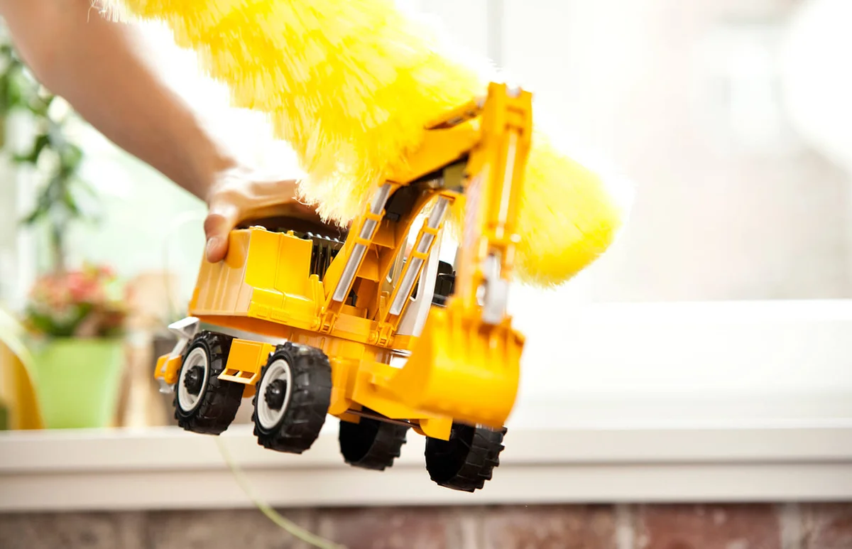 Woman dusting toy digger