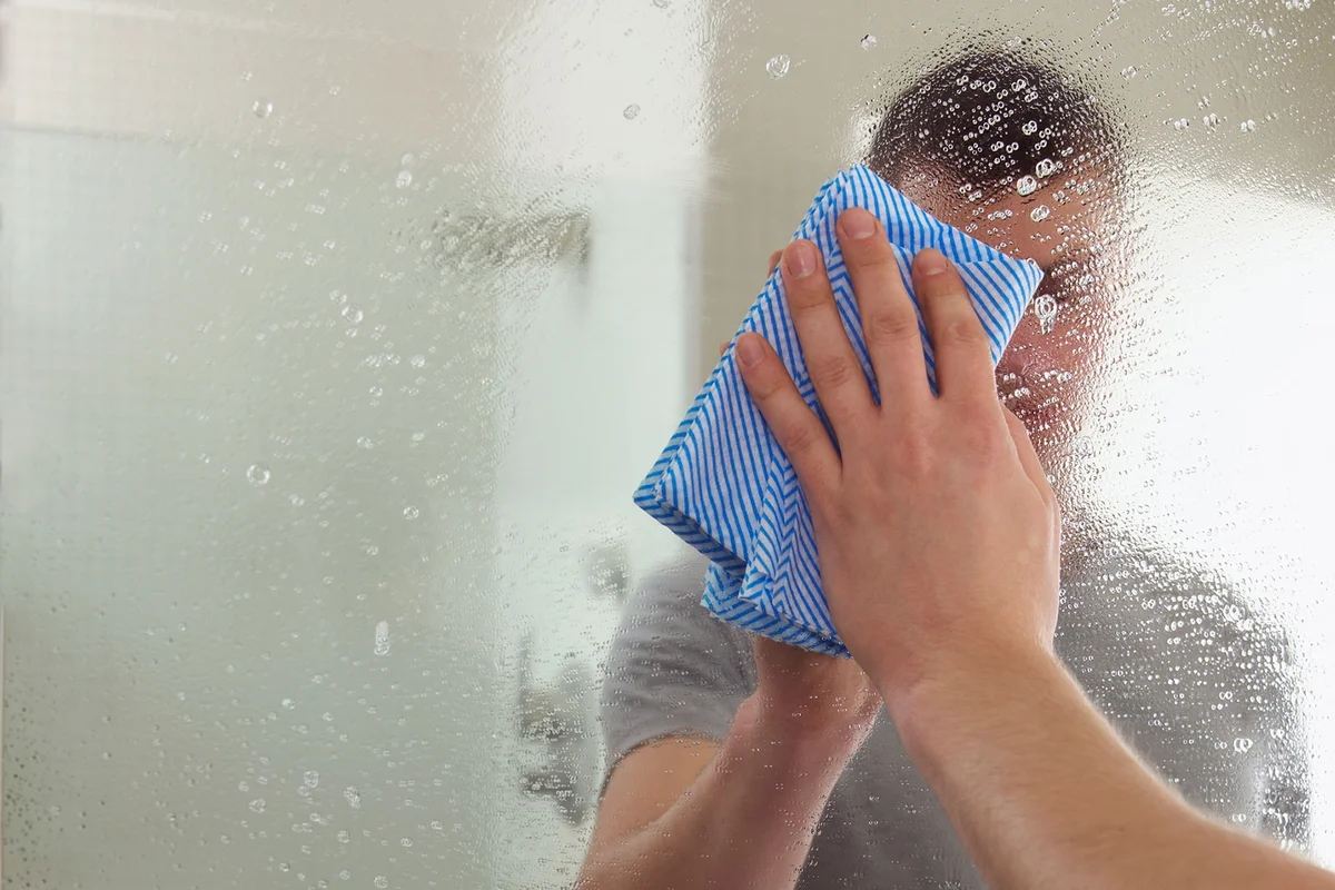 Man cleaning a mirror