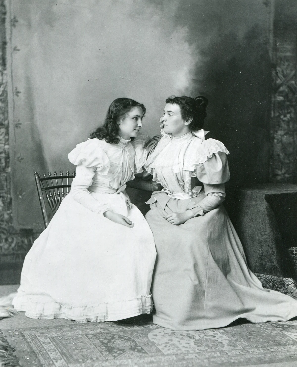 Helen Keller (left) 'listens' to her teacher, Anne Sullivan, 1897