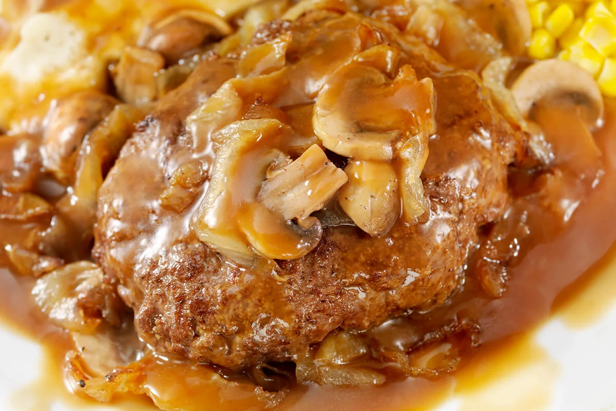 Salisbury Steak Topped with Sauteed Mushrooms and Onions, Mashed Potatoes and Corn on the side and topped with Gravy