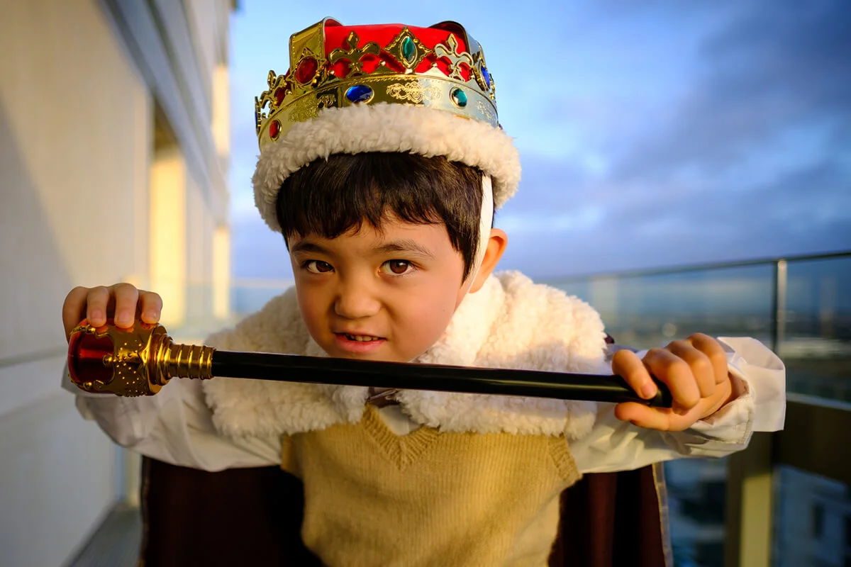 A young boy dressed as a King
