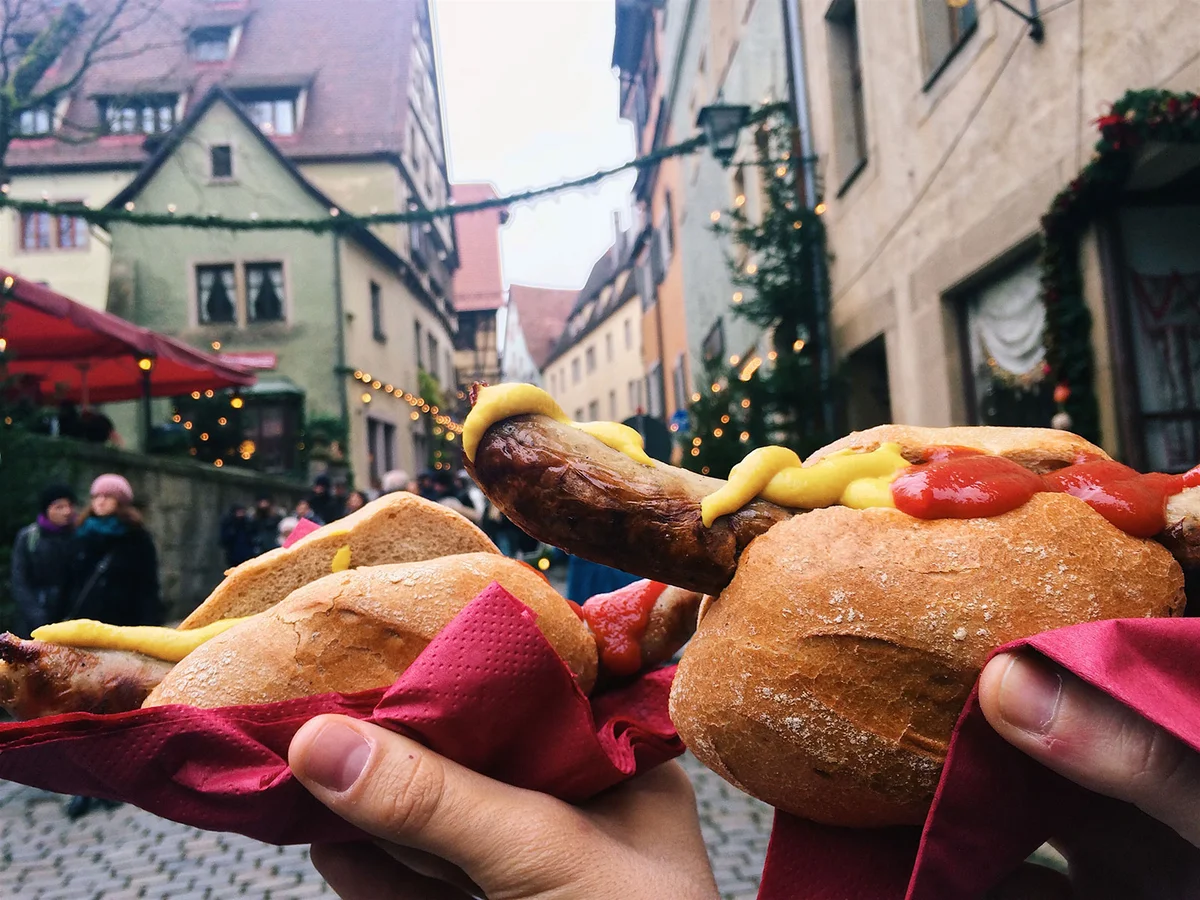 Eating bratwurst at Christmas market, Bavaria, Germany